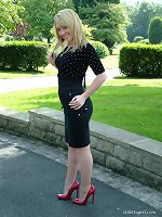 Cheeky blonde with very sexy red high heels on posing outdoors